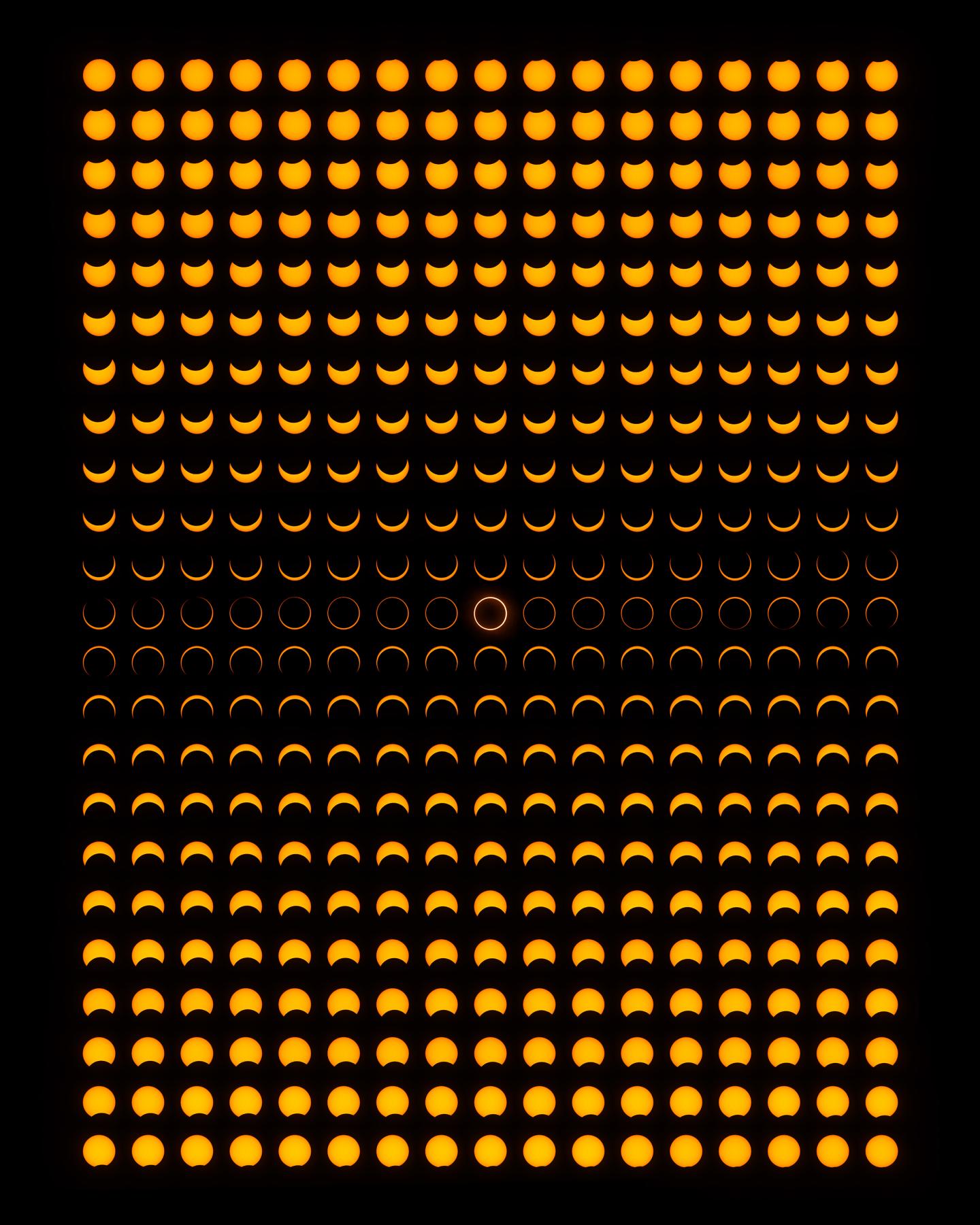Rectangular portrait image showing over 200 small images of the Sun lined up in rows, each one showing the progress of an annular solar eclipse with the black disk of the moon passing in front of the yellow disk of the sun. In the middle the black circle fits perfectly within the yellow circle, with a 'ring' of yellow around the edges.
